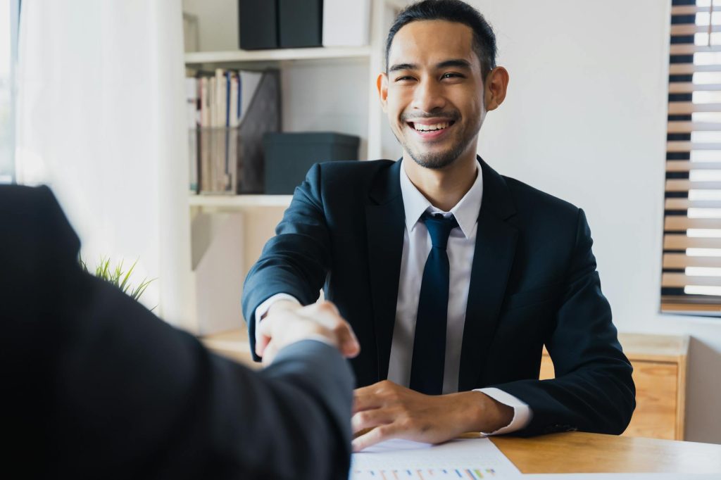 optimisation fiscale two businessman shake hand with partner to celebration partnership and teamwork business deal